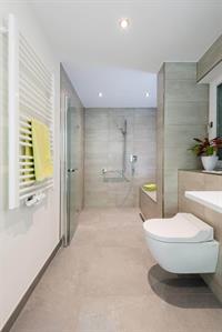 Rollstuhlgerechtes Badezimmer mit breitem Durchgang und übergangsloser Dusche