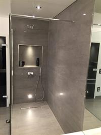 Große Dusche mit grauen Fliesen und Duschnische
