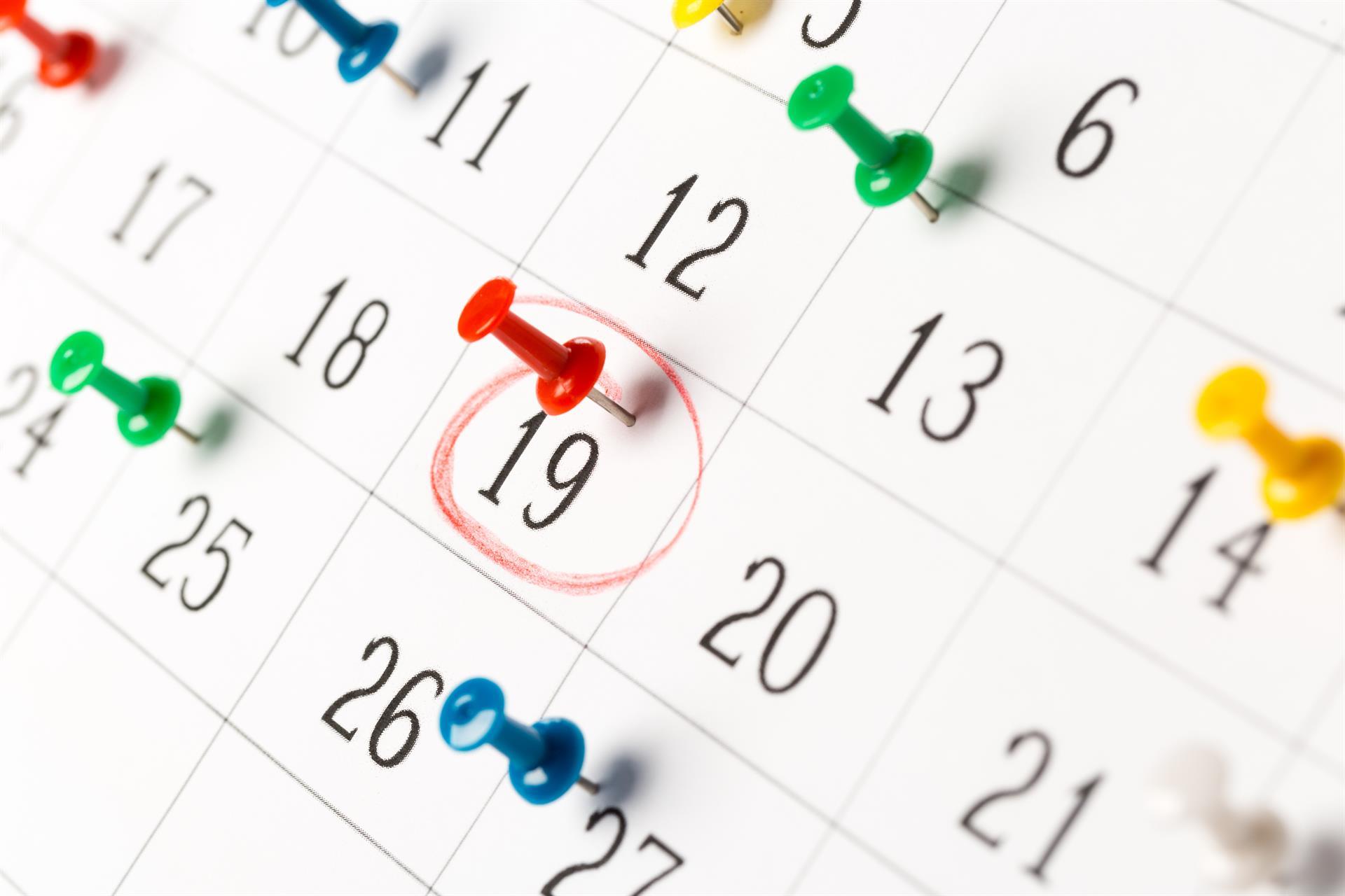 Eingekreiste und mit Pins versehene Daten in einem Kalender